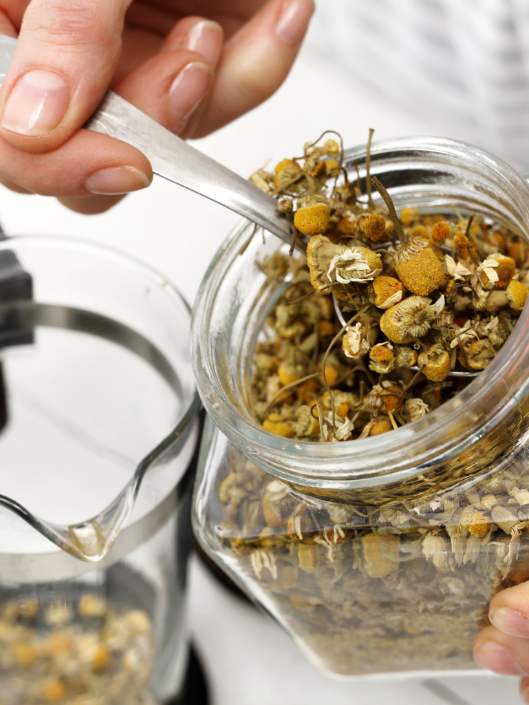 Chamomile being put in teapot